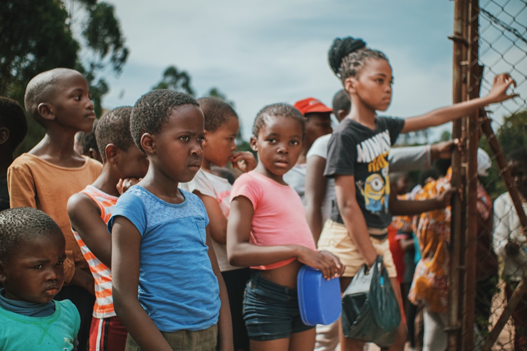 a-group-of-children-standing-next-to-each-other-k1coeoveuse