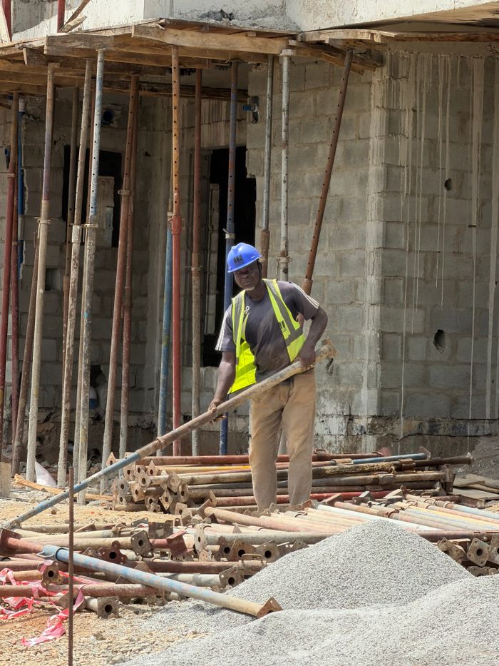 approach-img Construction worker operating at a building site, showcasing industry and development.